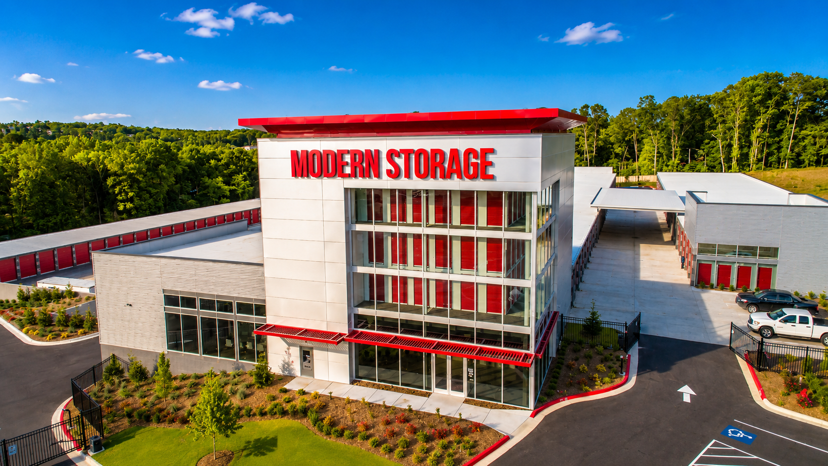 Modern Storage® West Little Rock Building Exterior Aerial exterior view of Modern Storage® West Little Rock featuring the front office tower, red architectural accents, landscaped grounds, and storage buildings.